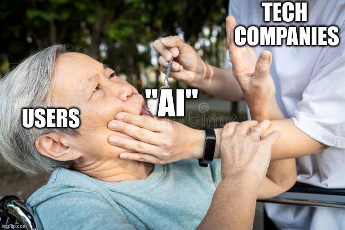 Un meme, basé sur le template « Force Feed ».
On y voit une personne âgée qui se débat pendant qu’une infirmière tente de la forcer à avaler une cuillerée de poudre.
Le texte au dessus de la personne âgée : « users »
Le texte au dessus de la cuiller : « “AI” »
Le texte au dessus de l’infirmière : « tech companies »